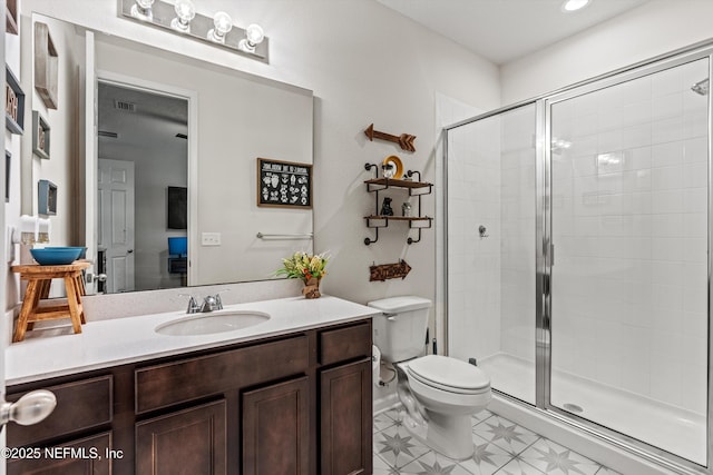 bathroom featuring vanity, toilet, and a shower with shower door