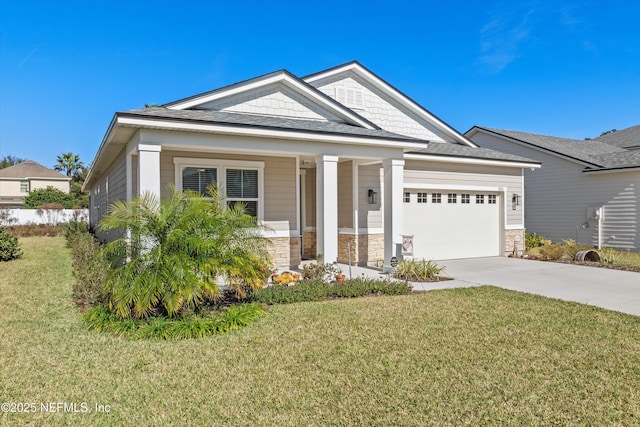 view of front of property featuring covered porch, a garage, and a front lawn