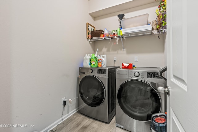 clothes washing area featuring light wood-type flooring and washer and clothes dryer