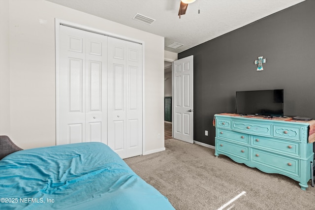 bedroom with ceiling fan, a closet, and light carpet