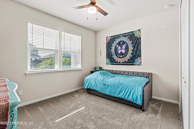 carpeted bedroom featuring ceiling fan and a textured ceiling