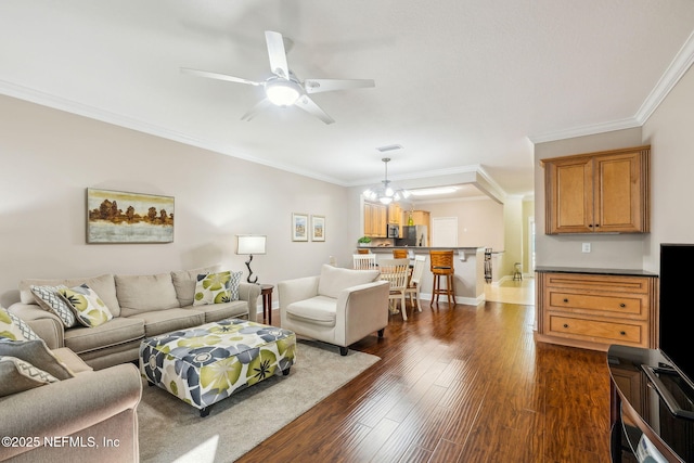 living room with ornamental molding, dark hardwood / wood-style flooring, and ceiling fan with notable chandelier