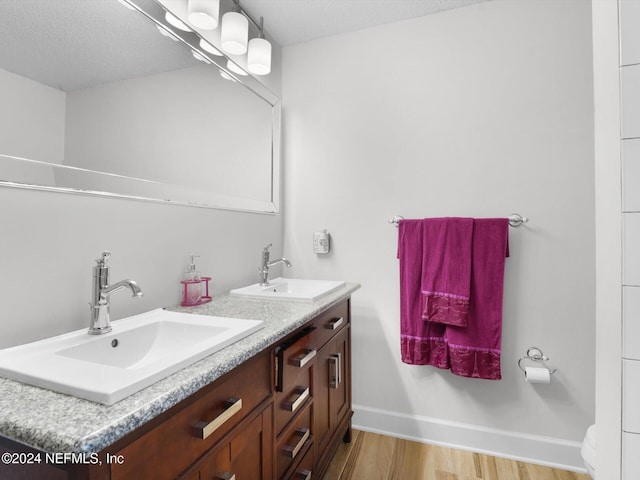 bathroom featuring hardwood / wood-style flooring, vanity, and a textured ceiling