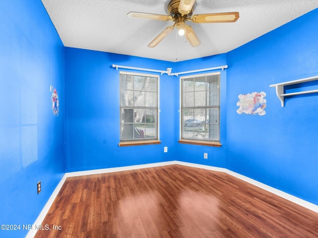 spare room featuring ceiling fan, wood-type flooring, and a textured ceiling