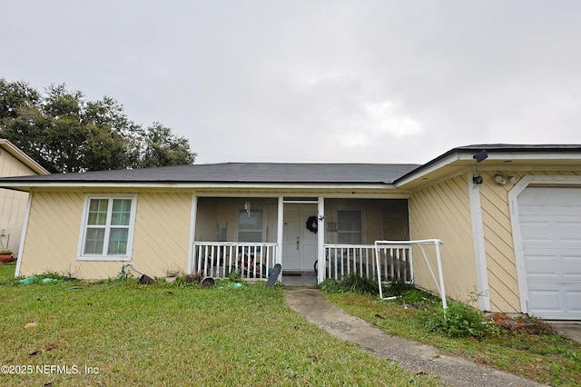 single story home featuring covered porch, a garage, and a front yard