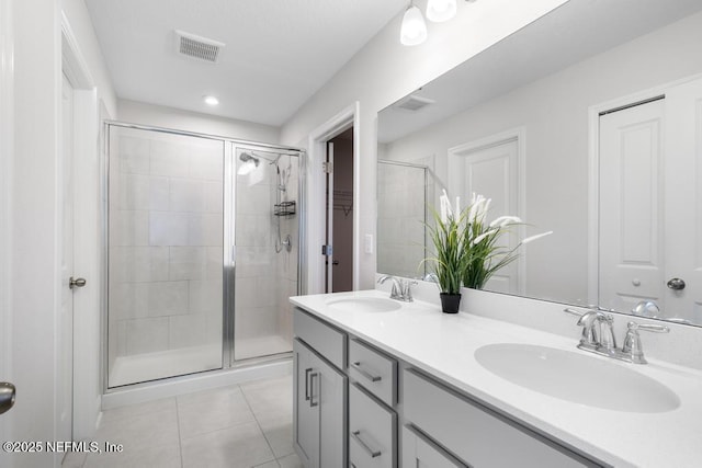 bathroom featuring tile patterned floors, vanity, and a shower with shower door