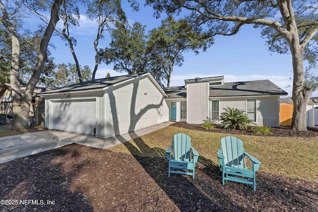 back of house featuring a yard and a garage