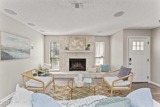 living room featuring hardwood / wood-style floors, a fireplace, and a textured ceiling