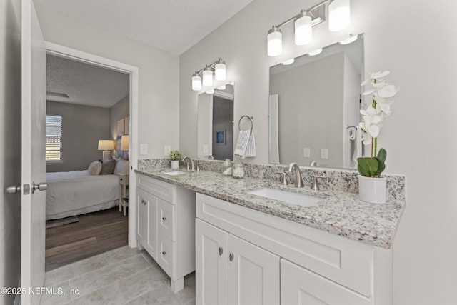 bathroom featuring tile patterned floors, vanity, and a textured ceiling