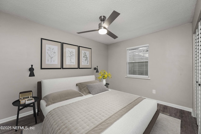 bedroom with a textured ceiling, ceiling fan, a closet, and dark hardwood / wood-style floors