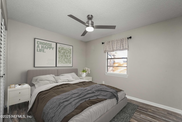 bedroom with ceiling fan, dark hardwood / wood-style flooring, and a textured ceiling