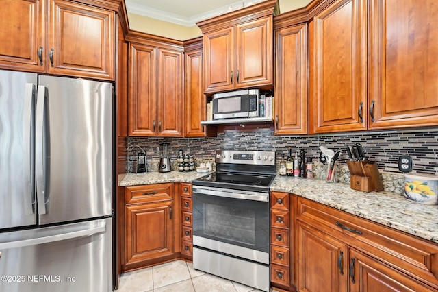 kitchen with backsplash, ornamental molding, stainless steel appliances, and light stone countertops