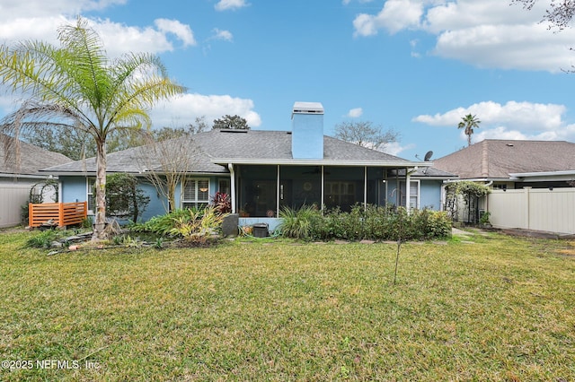 rear view of property with a lawn and a sunroom