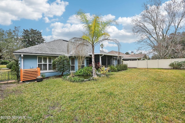 back of house featuring a sunroom and a lawn