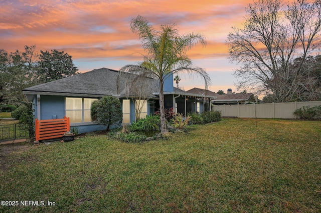 back house at dusk with a yard