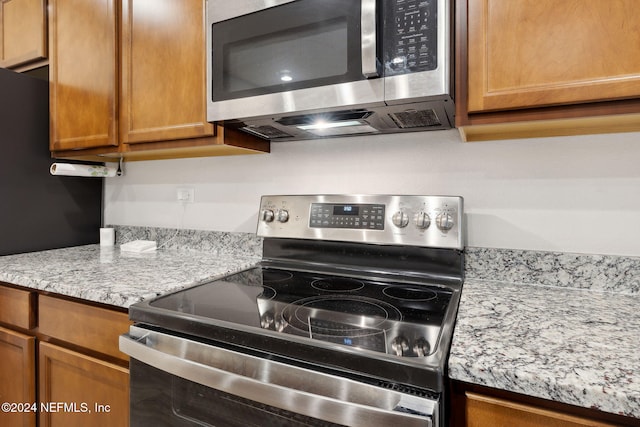 kitchen featuring light stone countertops and stainless steel appliances