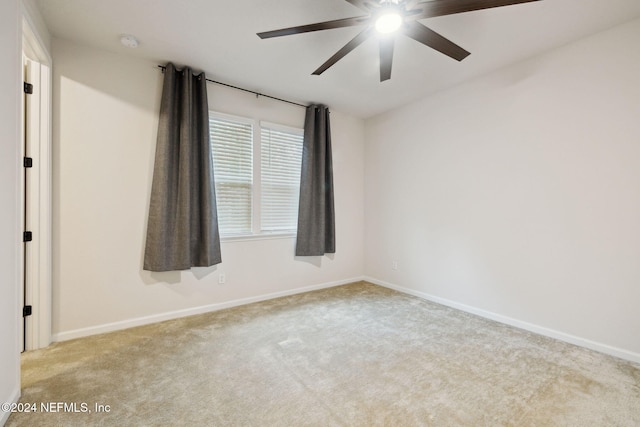 spare room with ceiling fan and light carpet