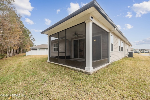 back of house featuring a sunroom, a yard, and central AC