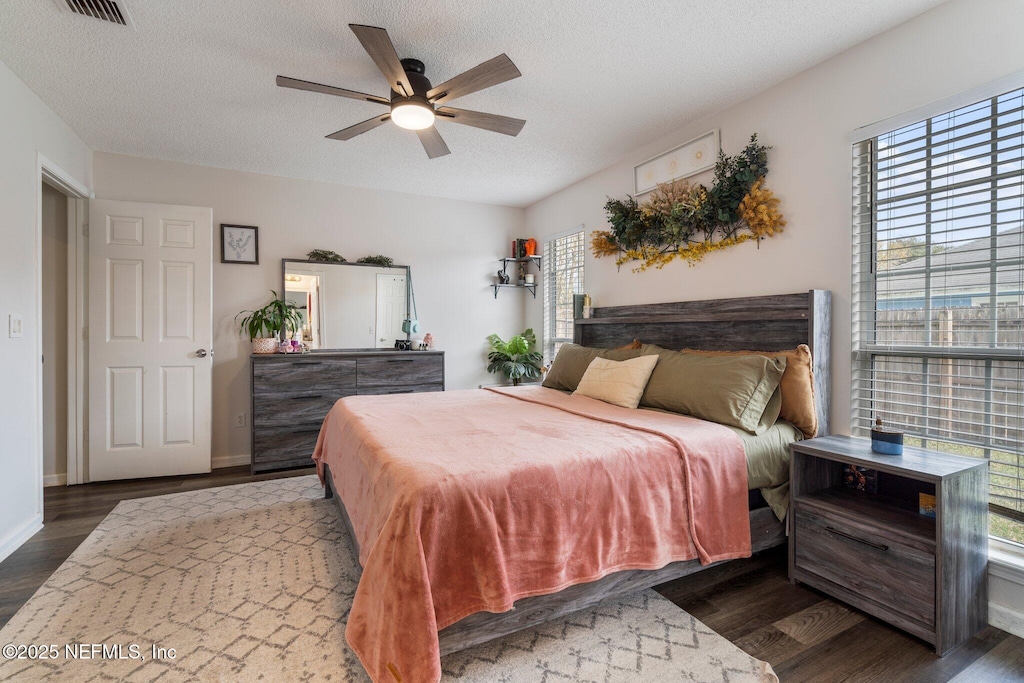 bedroom featuring a textured ceiling, ceiling fan, and dark wood-type flooring