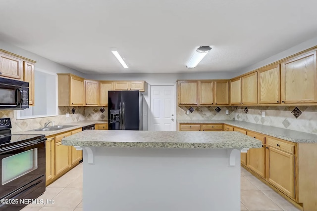 kitchen with light tile patterned flooring, black appliances, a kitchen breakfast bar, and a kitchen island