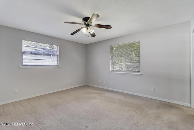 unfurnished room with light colored carpet and ceiling fan