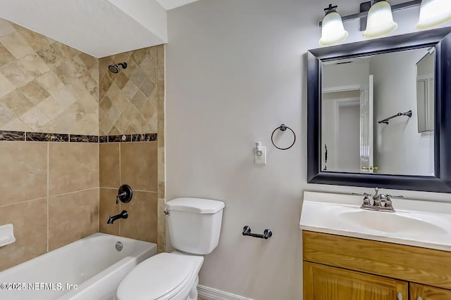 full bathroom featuring vanity, tiled shower / bath combo, and toilet