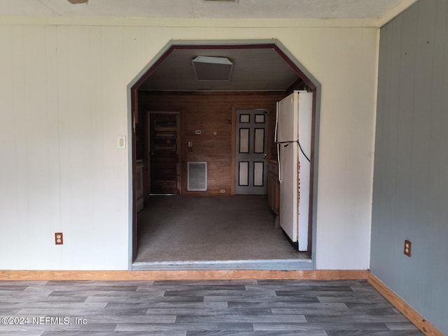 interior space with wood-type flooring and wooden walls