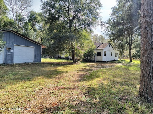 view of yard with a garage and an outbuilding