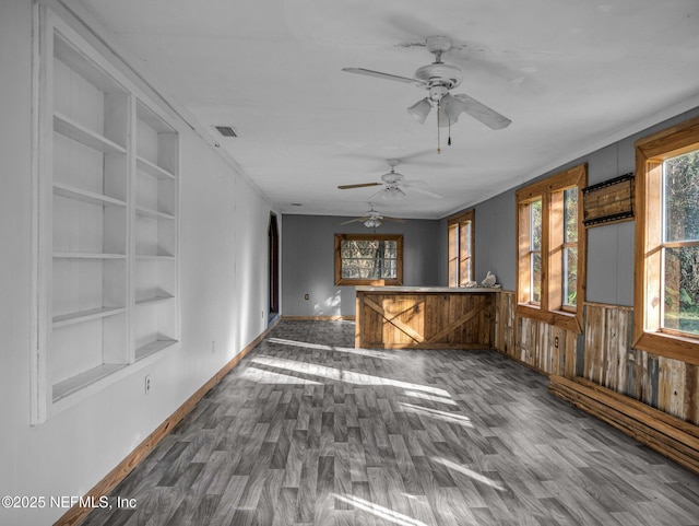 interior space with built in shelves, ceiling fan, and hardwood / wood-style flooring