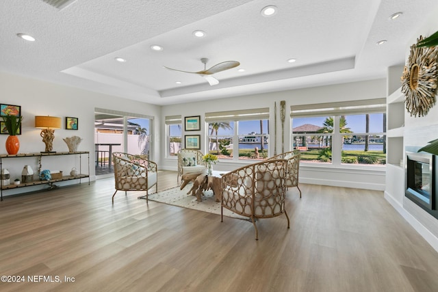 interior space featuring a tray ceiling, ceiling fan, and a healthy amount of sunlight