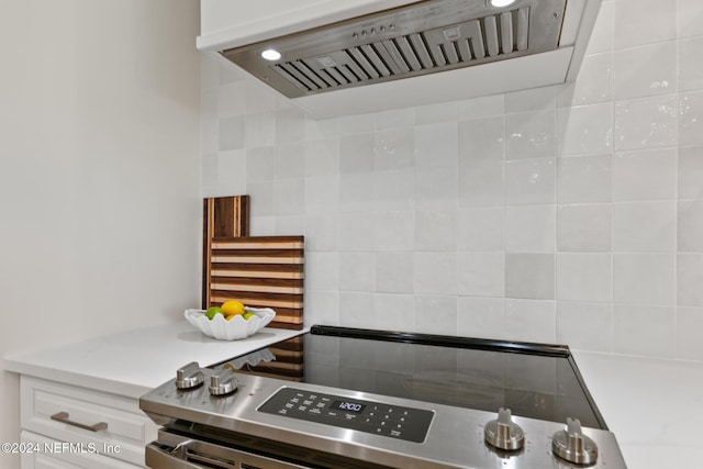 kitchen featuring white cabinets, stainless steel range oven, and range hood