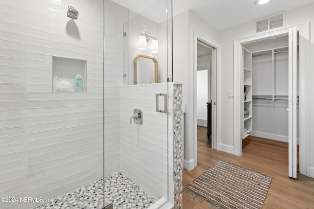 bathroom featuring hardwood / wood-style floors and a shower with shower door