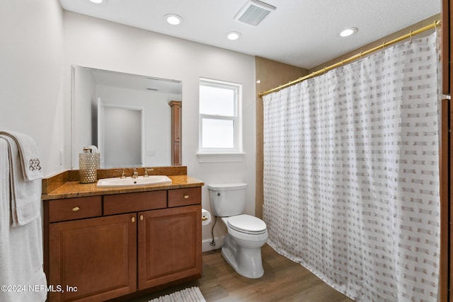 bathroom featuring hardwood / wood-style floors, vanity, toilet, and walk in shower