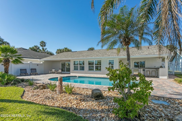 view of swimming pool with a bar and a patio