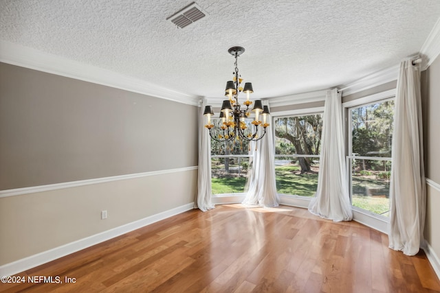 unfurnished dining area featuring a notable chandelier, ornamental molding, and a wealth of natural light