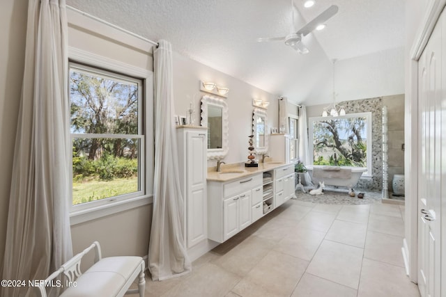 bathroom with tile patterned flooring, vanity, a textured ceiling, and vaulted ceiling