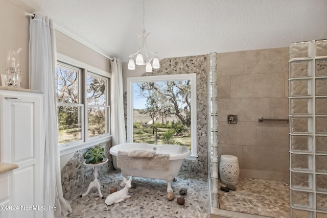 bathroom featuring plus walk in shower, a textured ceiling, and a notable chandelier