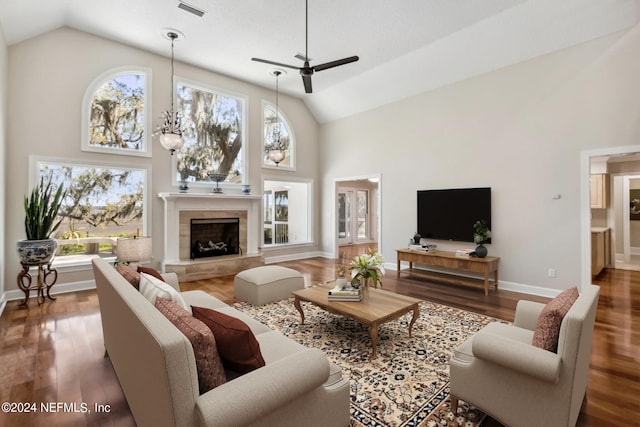 living room with ceiling fan with notable chandelier, dark hardwood / wood-style floors, and high vaulted ceiling