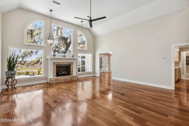 unfurnished living room featuring hardwood / wood-style floors, ceiling fan with notable chandelier, and high vaulted ceiling