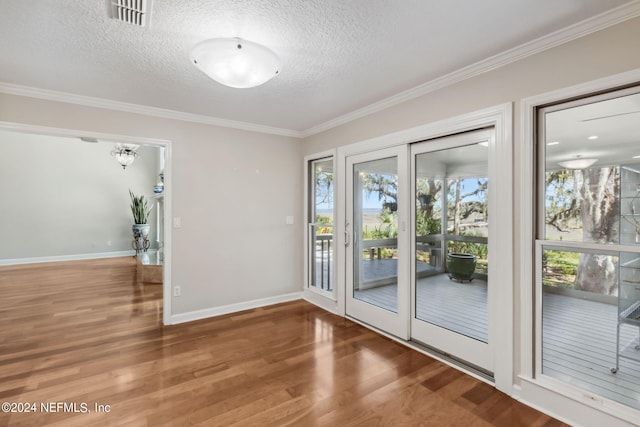 entryway featuring hardwood / wood-style floors, a healthy amount of sunlight, a textured ceiling, and ornamental molding