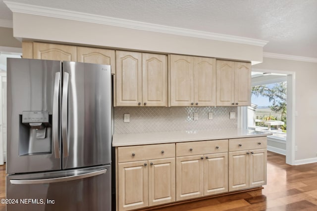 kitchen featuring tasteful backsplash, stainless steel fridge with ice dispenser, crown molding, hardwood / wood-style floors, and light brown cabinetry