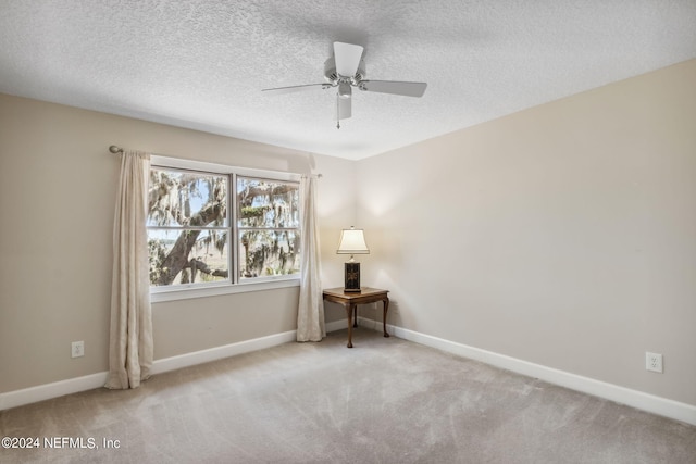 carpeted empty room featuring ceiling fan and a textured ceiling