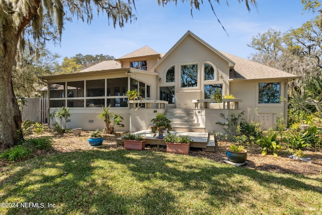 back of house with a sunroom and a lawn