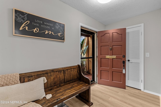 foyer featuring light hardwood / wood-style floors and a textured ceiling