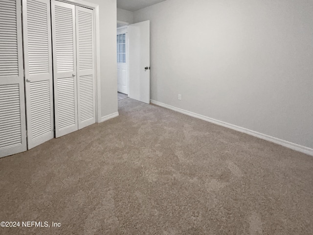 unfurnished bedroom with light carpet and a closet