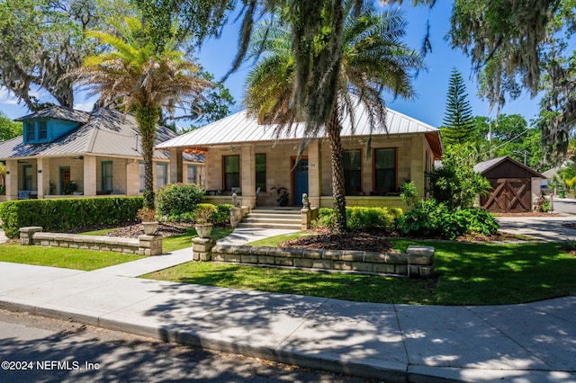 view of front of property featuring a porch and a storage unit