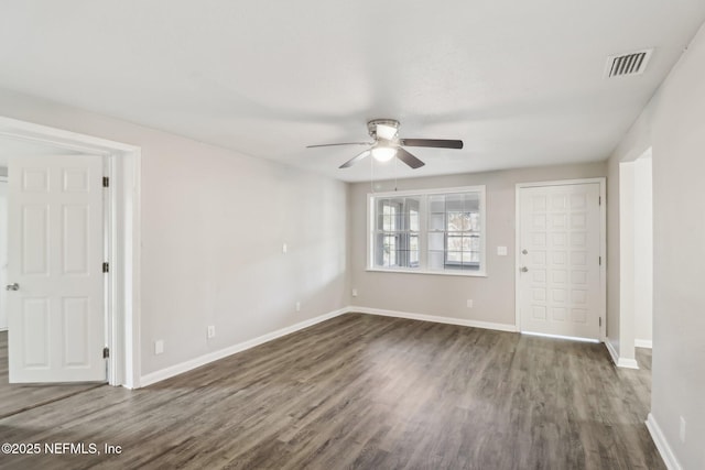 empty room featuring dark hardwood / wood-style flooring and ceiling fan