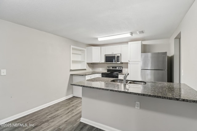 kitchen with white cabinetry, sink, dark stone counters, a textured ceiling, and appliances with stainless steel finishes