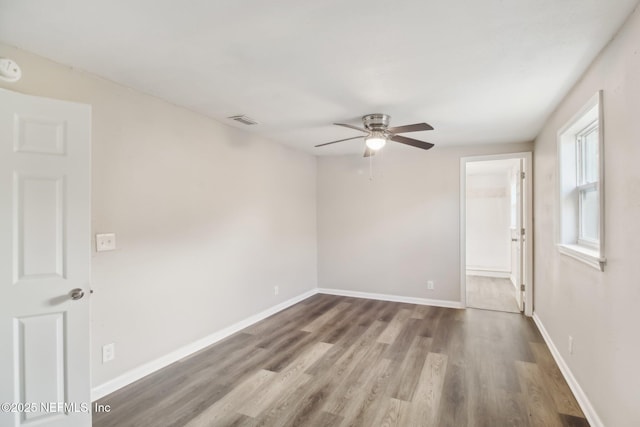 empty room featuring wood-type flooring and ceiling fan