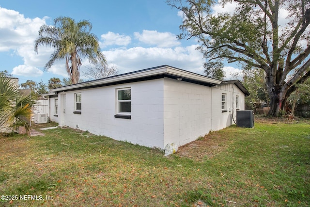 view of home's exterior featuring central AC unit and a lawn